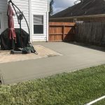 shaped concrete patio in backyard